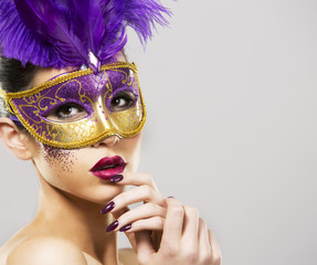 paarty woman swearing golden mask on light backgound