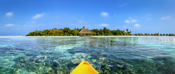 Sicht von einem Kanu auf Malediven Insel über türkises Meer und Korallen