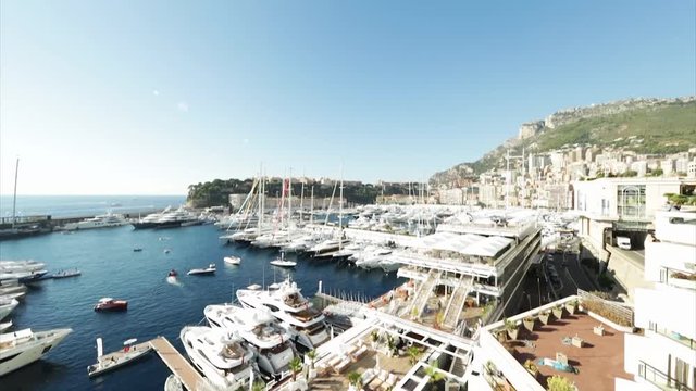World Fair MYS Monaco Yacht Show, Port Hercules, luxury megayachts, many shuttles, taxi boat, presentations, Journalists, boat traffic, Azur water, aerial view, mountains on background, perspective