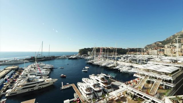 World Fair MYS Monaco Yacht Show, Port Hercules, luxury megayachts, many shuttles, taxi boat, presentations, Journalists, boat traffic, Azur water, aerial view, mountains on background, perspective