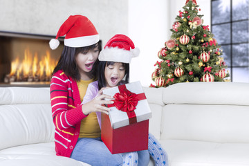 Young mother and little girl surprised with gift