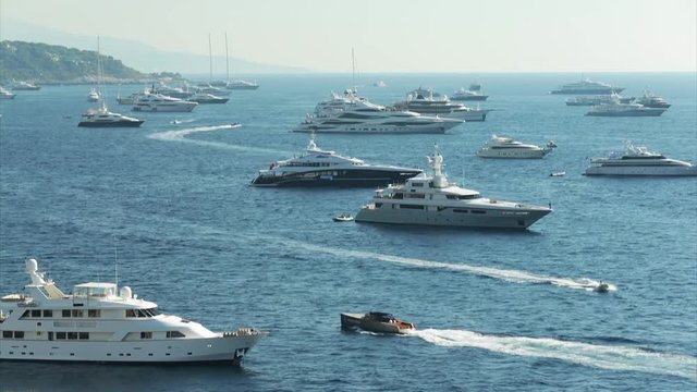 World Fair MYS Monaco Yacht Show, Port Hercules, luxury megayachts, many shuttles, taxi boat, presentations, Journalists, boat traffic, Azur water, aerial view, mountains on background, perspective
