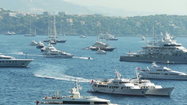 World Fair MYS Monaco Yacht Show, Port Hercules, luxury megayachts, many shuttles, taxi boat, presentations, Journalists, boat traffic, Azur water, aerial view, mountains on background, perspective