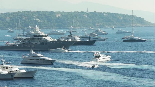 World Fair MYS Monaco Yacht Show, Port Hercules, luxury megayachts, many shuttles, taxi boat, presentations, Journalists, boat traffic, Azur water, aerial view, mountains on background, perspective