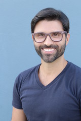 Handsome brunette bearded man with glasses smiling close up