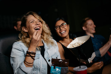 Young woman with friends watching movie - obrazy, fototapety, plakaty