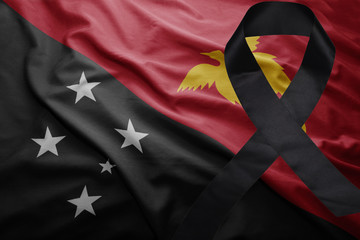 flag of Papua New Guinea with black mourning ribbon