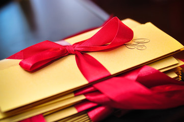 gold wedding invitation with red ribbon