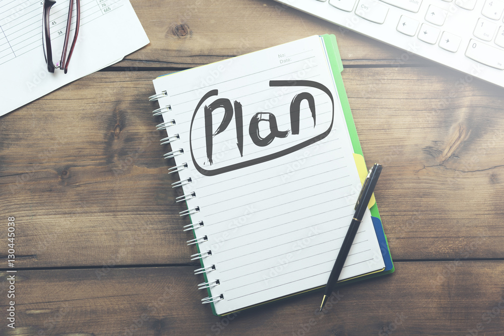 Poster plan text on notepad and keyboard
