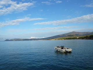 Fototapeta na wymiar Krajobraz Morski - motorówka na tle wybrzeża (Wyspa Thassos)