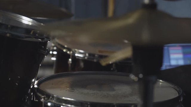 Closeup details drum set man hands playing. Male plays drumsticks on drums kit. Person on the concert pop or rock band.