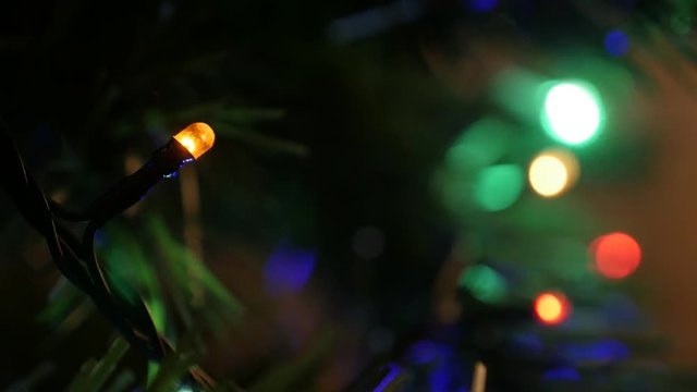 Christmas LED bulbs on artificial spruce 4K 2160p 30fps UltraHD video - Colorful dot tree lights blinkling in dark close-up 3840X2160 UHD footage 