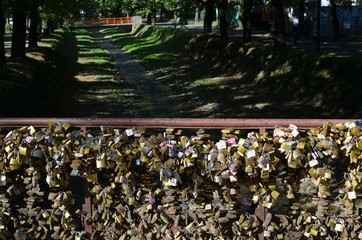 Bridge of Love fence with lots of padlocks and rivulet with riverbed