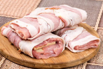 Closeup macro view stuffed meat with yellow cheese in bacon