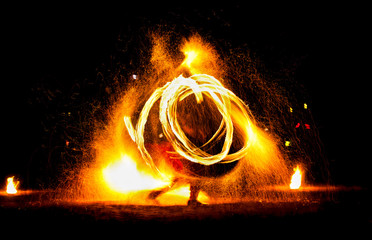 Man entertains the audience with the help of fire, carrying fire performance night.
