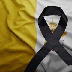flag of vatican city with black mourning ribbon
