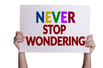 Never stop wondering card in hand isolated on white background