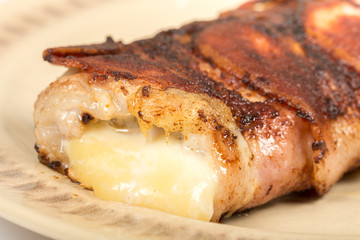 Melted yellow cheese in rolled steak with bacon