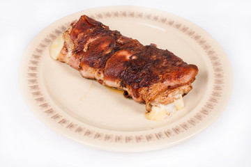 Melted yellow cheese in rolled steak with bacon