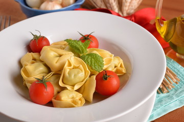 of tortellini dish with tomatoes on table