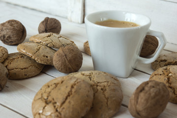 Cup of coffee, macaroons cookies  and walnut on the white wooden background