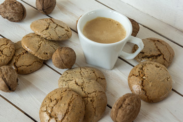 Cup of coffee, macaroons cookies  and walnut on the white wooden background