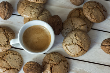 Cup of coffee, macaroons cookies  and walnut on the white wooden background