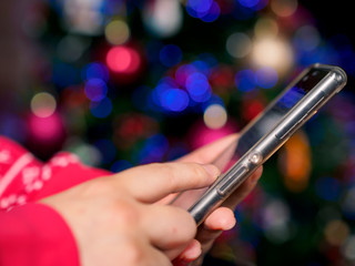 shopping online by mobile phone against christmas light backgroud