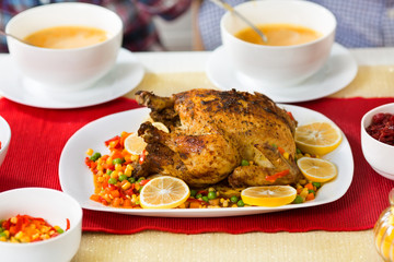 Roasted chicken with gravy and vegetable side dishes served as part of the holiday's meal