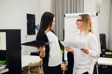 Fototapeta premium Two beautiful young executives reading some papers