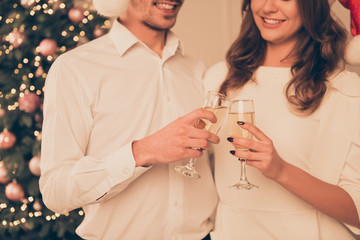 Close up of smiling man and woman clincking with glasses of cham