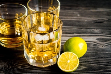 glass of whiskey on dark wooden background