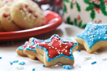 Xmas star shaped cookies  with red and blue royal icing on holiday background, selective focus
