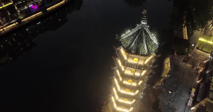 View of illuminated riverside houses, oriental ancient watch tower in Fenghuang,Hunan province,China. The town was added to the UNESCO World Heritage Tentative List on March 28,2008.