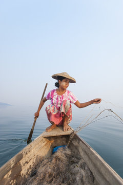 A young woman pulls in her nets at the end of the day on Indawgyi Lake, Kachin State