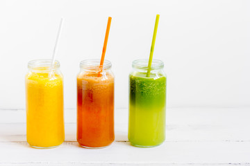Fresh detox juices in glass bottles on white background