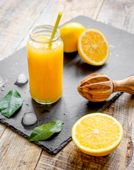 Fototapeta na wymiar freshly squeezed orange juice in glass bottle on wooden background