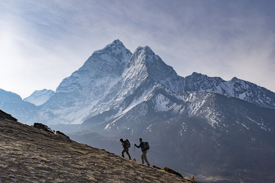 Trekkers climb a small peak above Dingboche in the Everest region in time to see the sunrise, with Ama Dablam in the distance, Himalayas, Nepal