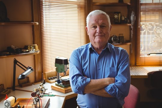 Portrait of horologist standing with arms crossed