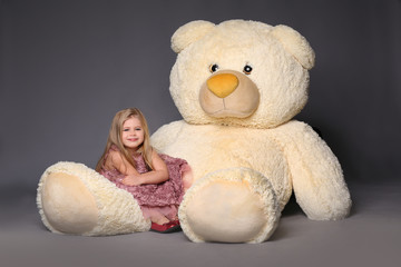 Baby sitting on the large teddy bear