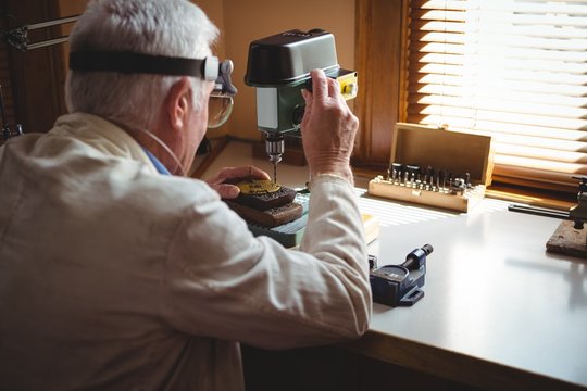 Horologist drilling a dial plate - Powered by Adobe
