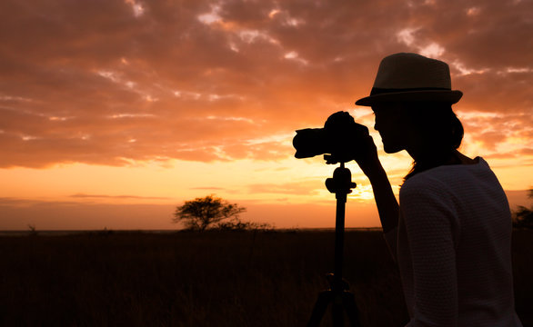 Female photographer taking photos during sunset. 