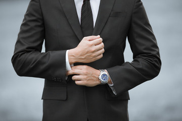 Closeup of man wearing suit and watch. 