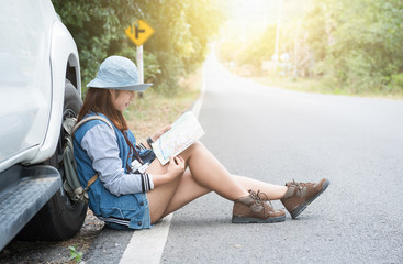 Hipster young woman looking for way during her road-trip.