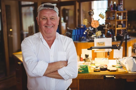 Portrait of horologist standing with arms crossed