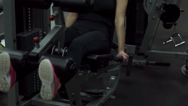 Blonde girl training at the gym. Woman engaged in fitness