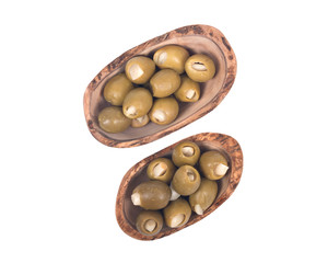 Green colossal olives hand stuffed with garlic gloves in olive wood bowl isolated on white background