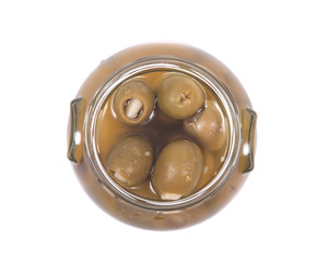 Green colossal olives hand stuffed with garlic gloves in jar isolated on white background