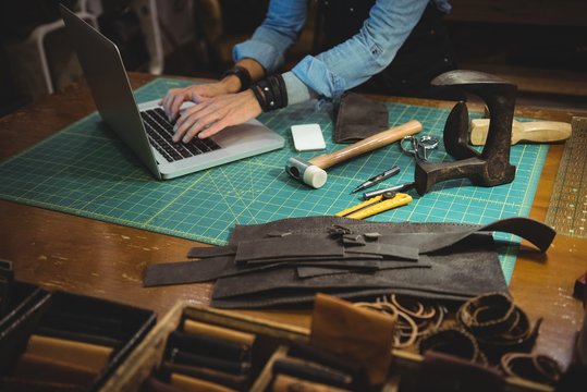 Craftswoman using laptop in workshop