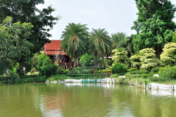 Fototapeta na wymiar Thai Classic house next to lake in public garden.